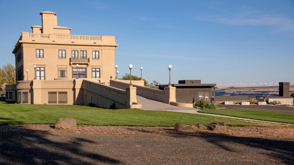 Maryhill Museum of Art, with the stone bulding on the left side of the photo and a green lawn in the foreground