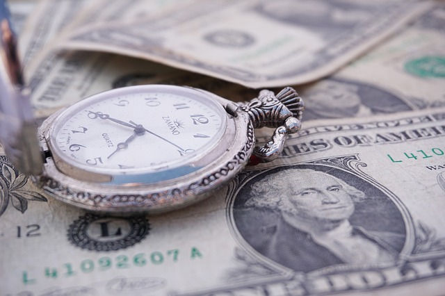 A pocket watch on dollar bills.