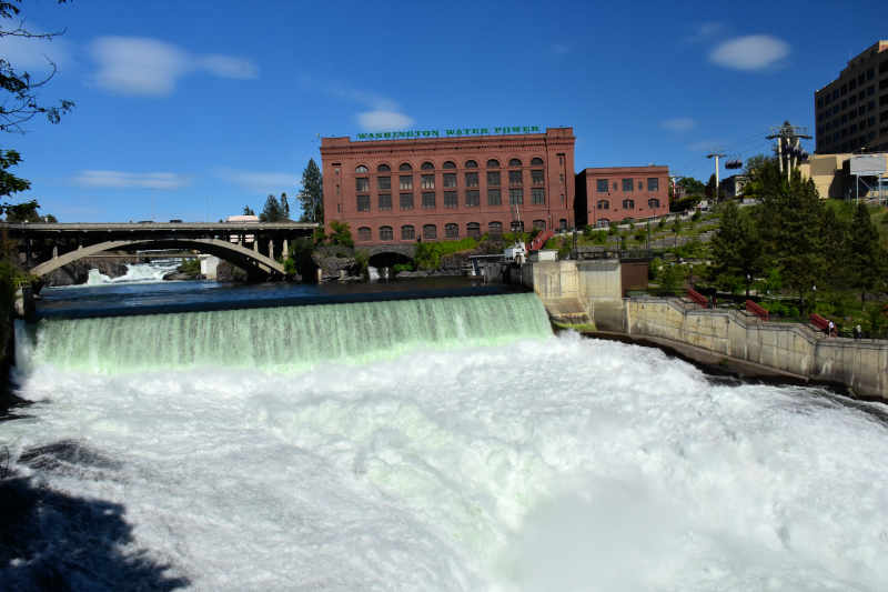 the beautiful spokane falls is right in the center of town in spokane washington with buildings and a bridge