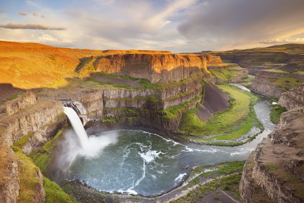The official waterfall of Washington State, Palouse Falls, taken of the waterfall cascading into the river below which forms a beautiful canyon snaking through the landscape.