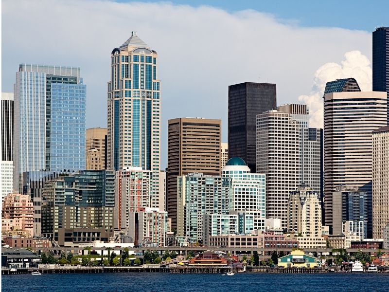 Seattle architecture with a view of the waterfront and water on a partly cloudy day.