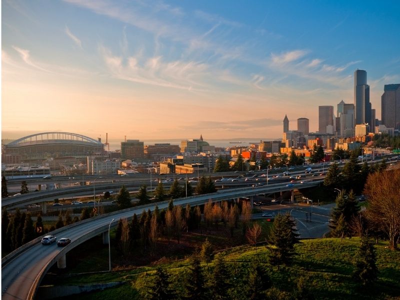 Seattle sunset with skyline and cars on the highways with no traffic.