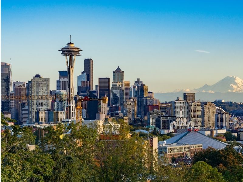 Seattle skyline and snow-capped Mount Rainier on a cloudless sunny day, a rare occurence as you can probably guess from these Seattle quotes about rain!