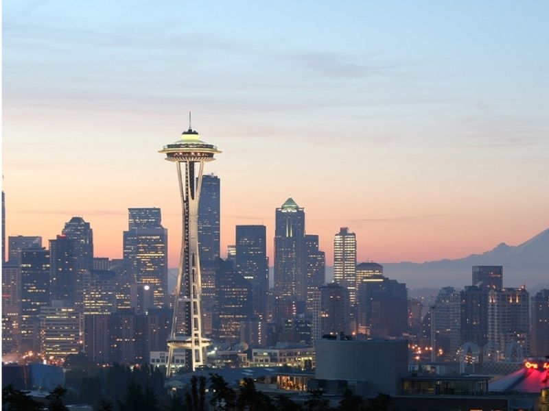 Space Needle and the rest of the Seattle skyline shown at sunset when all the lights come on in the city.