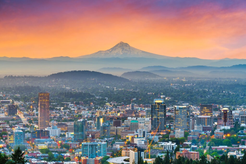 skyline of portland oregon at sunset with mount hood visible in the distance