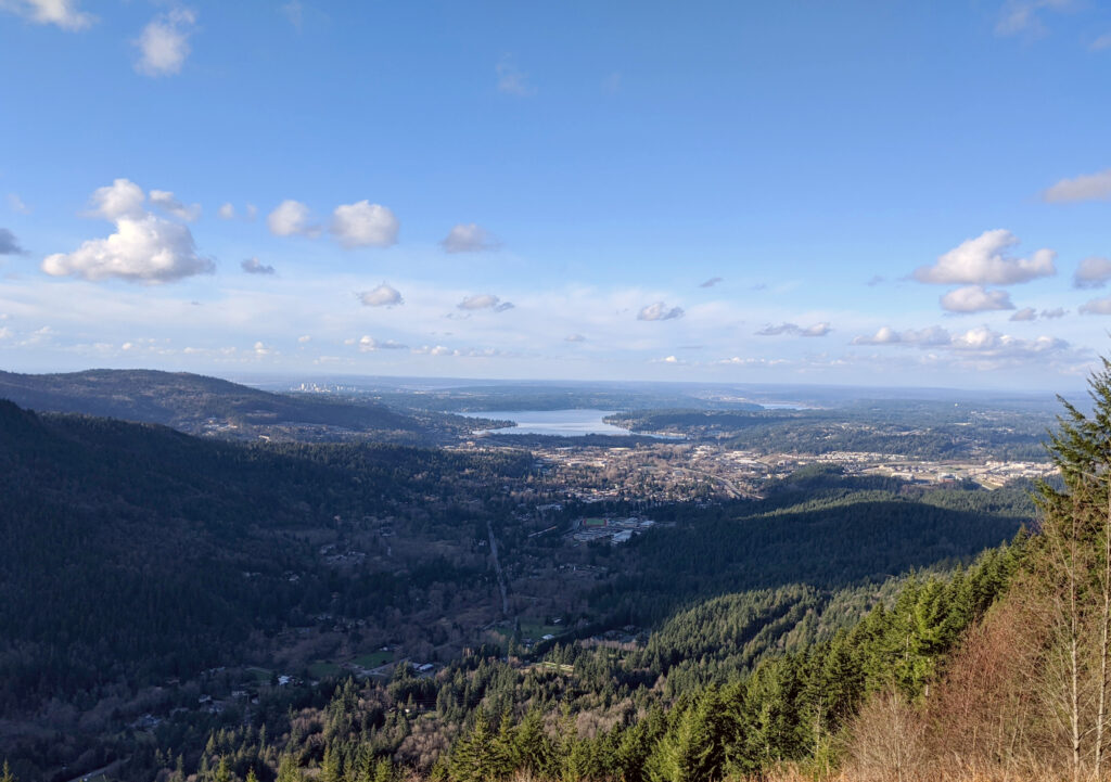 view from poo poo point seattle, with a lake and seattle skyline visible in the distance