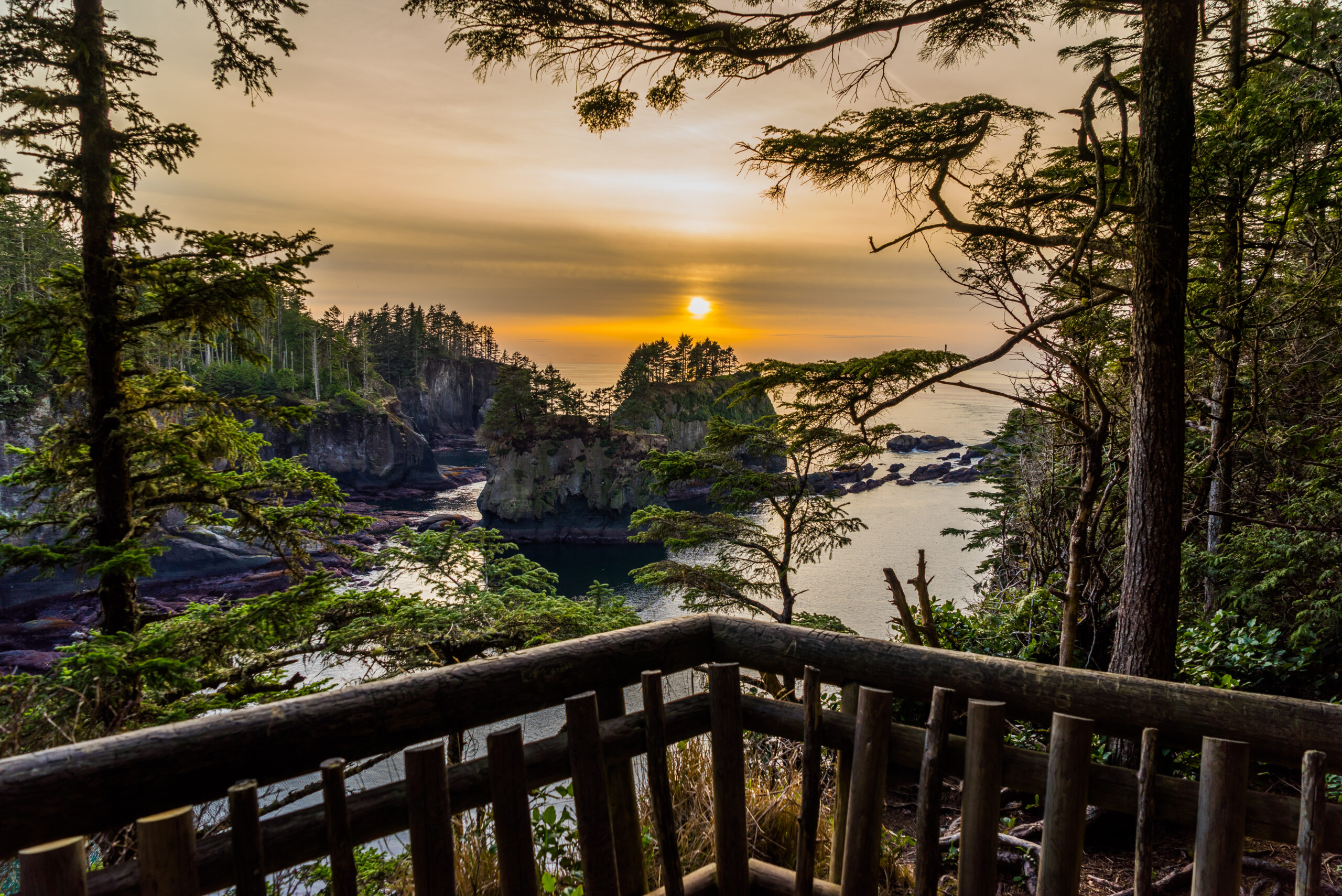 sunset over the pacific ocean in olympic national park, as seen from a wooden deck. olympic national park is one of the best road trips from seattle washington.