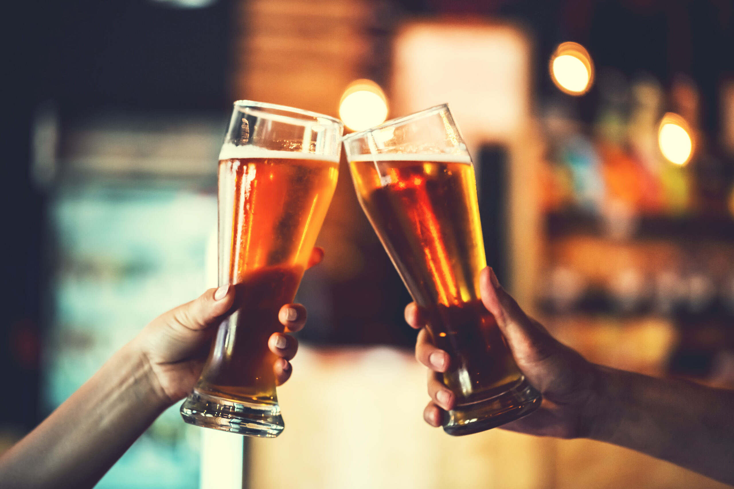 two beers being held up to toast. craft breweries are among the best things to do in bend or