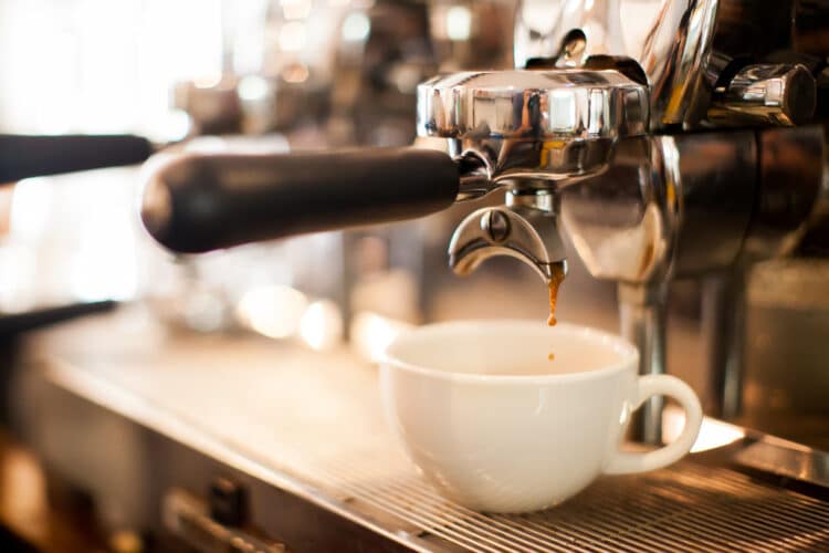 espressso machine pulling a cup of coffee into a white cup. espresso is a staple as the best bend coffee shops