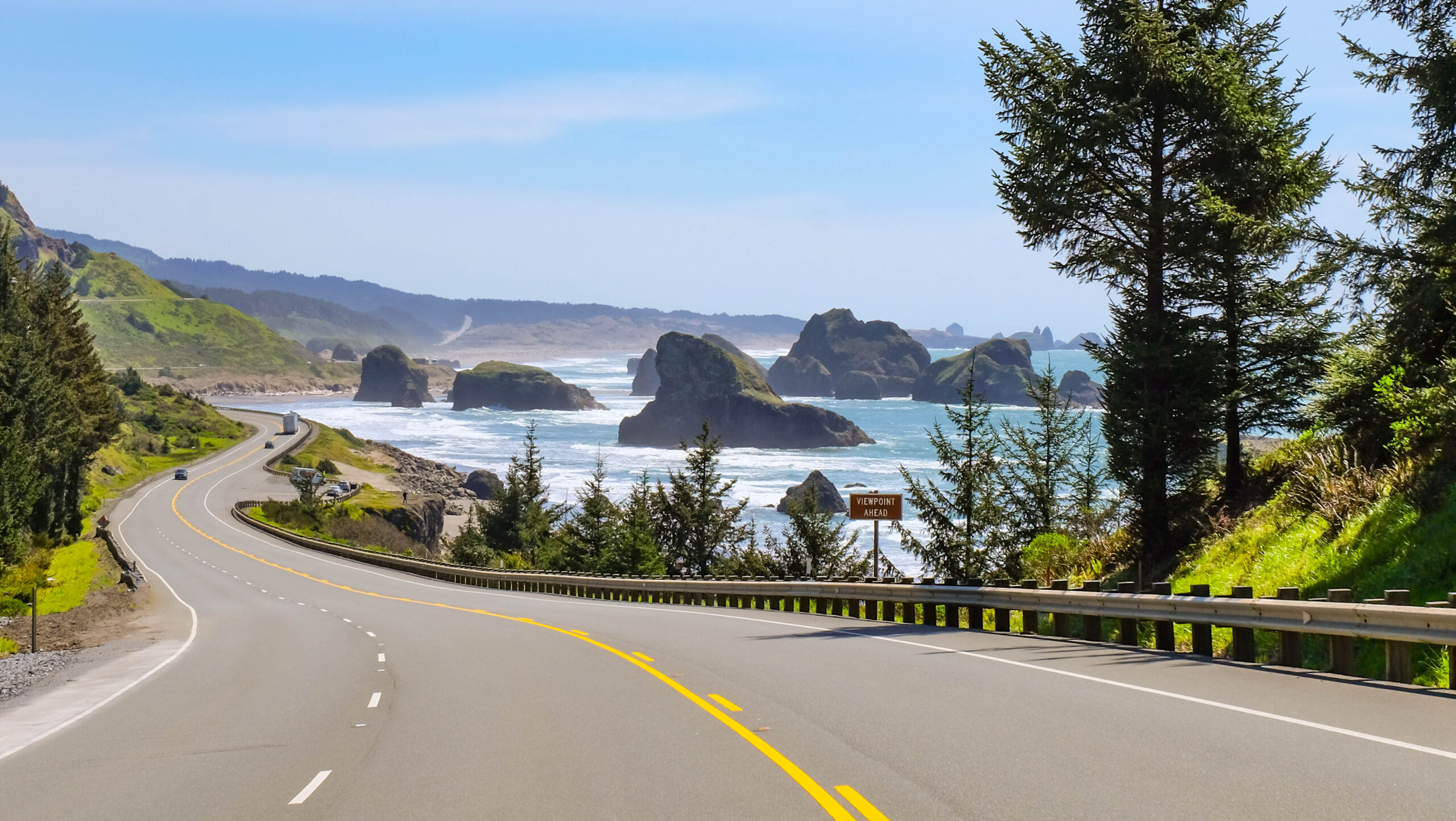 coastal oregon road trip with road to the left and ocean to the right of the photo