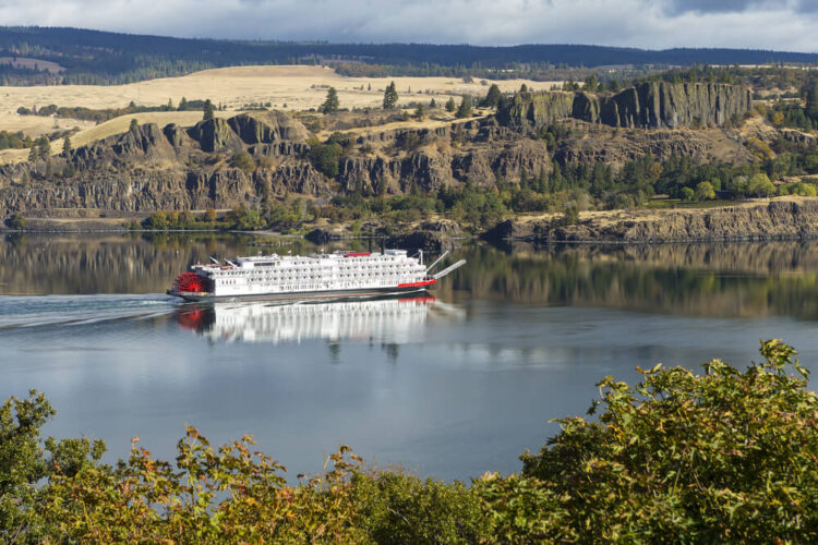 An old fashioned paddle boat (white boat with red paddle) going on the Columbia River