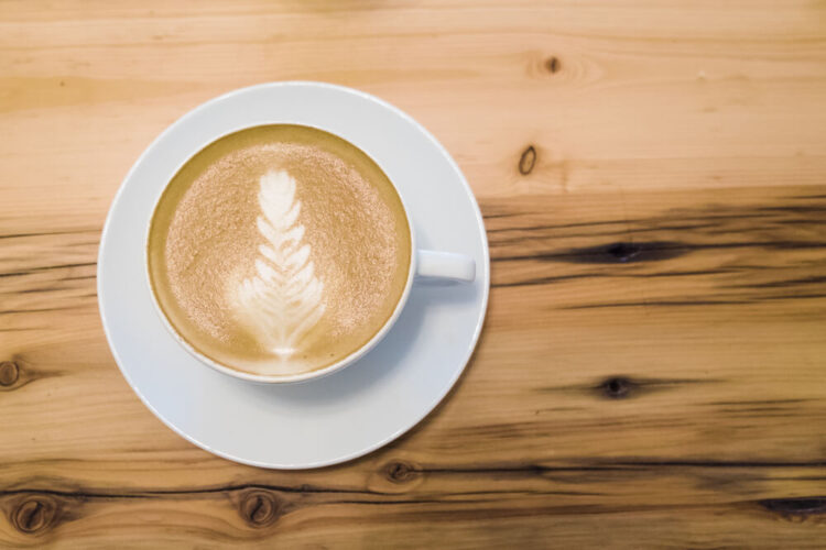 A perfect cup of coffee with latte art on a wooden table.