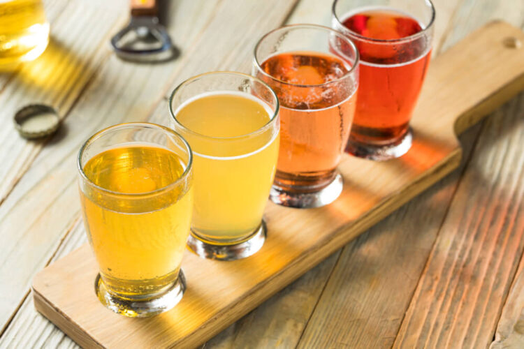 Flight of four ciders, ranging from a light golden color to a deep almost red color.