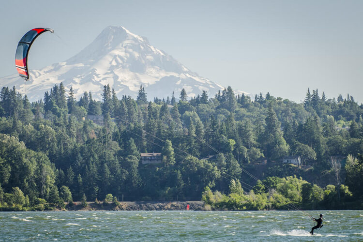 Person kitesurfing on the Columbia River with a snow-covered Mt Hood in the background