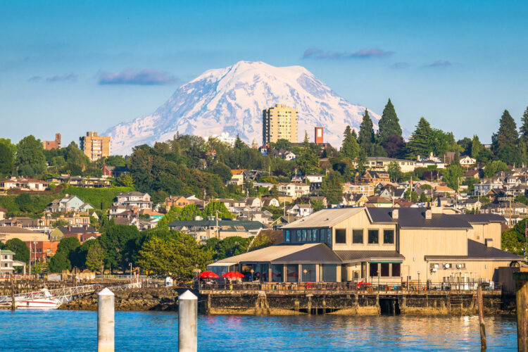 the beautiful seaside city of tacoma near seattle. glaciated mountain, skyline with large buildings and lots of green space, and a harbor in the scene.