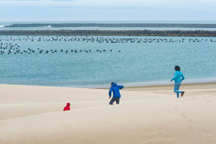 3 children running over dunes in winchester, one of the best beach towns in oregon