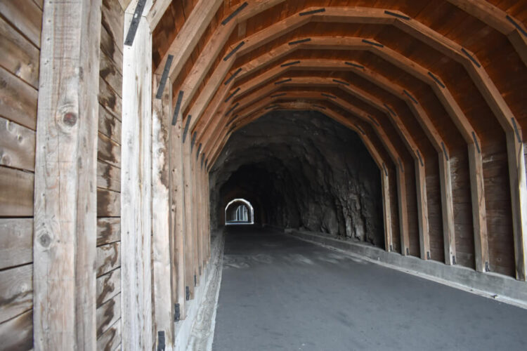 A covered wooden tunnel with you can see light at the other end at, part of the Columbia river trail