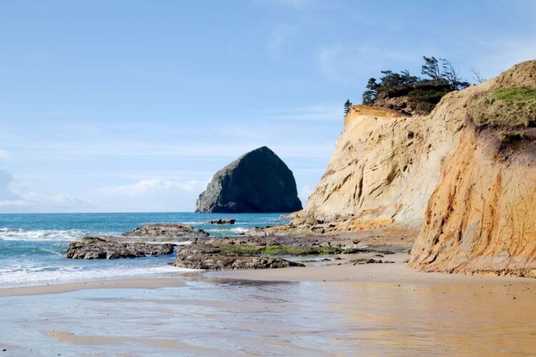 sandy beach, rock formations, and orange sandy cliffs on the edge of the water