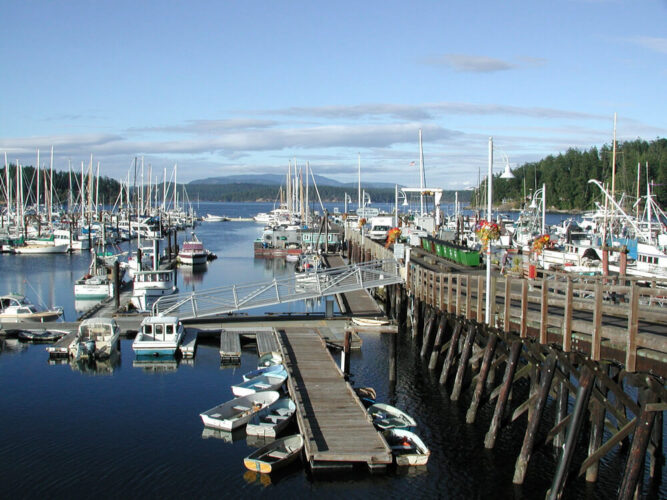 Wooden pier with many small boats and sailboats in the marina at Friday Harbor in Washington's San Juan Island.