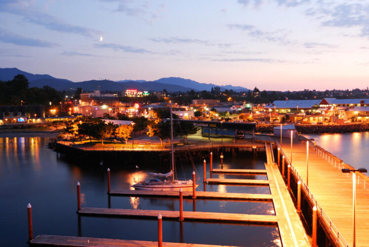 the coastal town of port angeles as seen after the sunset with the marina docks lit up at night