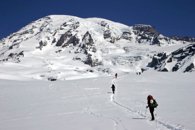 people hiking through the snow during winter at mount rainier