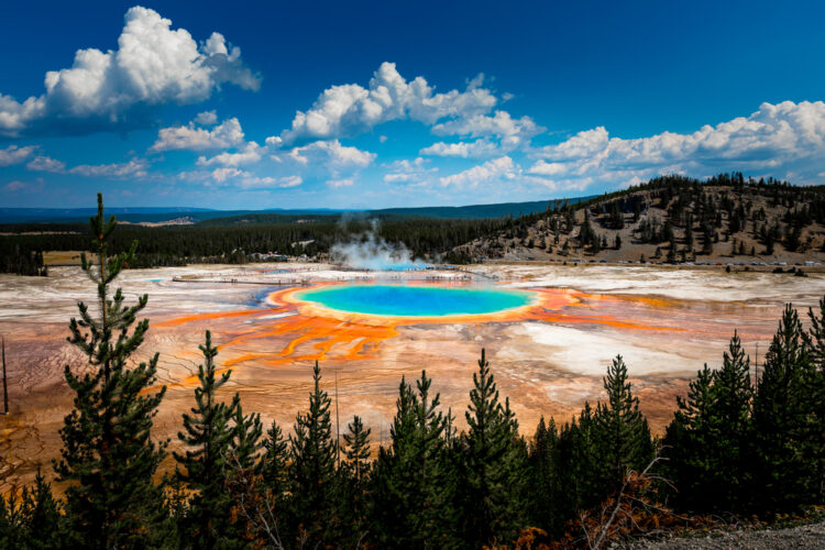 Bright blue geyser ringed with orange iron deposits, seen from above at Grand Prismatic Spring in Yellowstone, a great Idaho weekend getaway